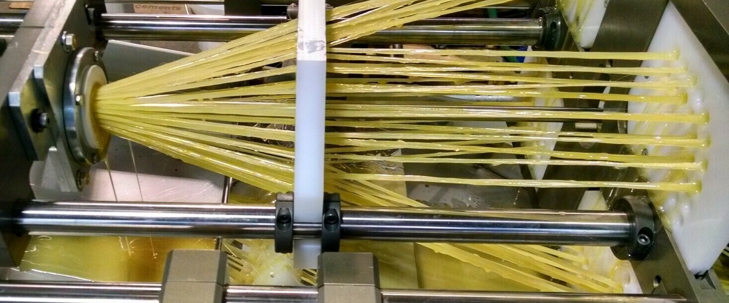 Pultrusion Infeed Section Infeed section of a pultrusion machine showing rovings wetted with resin.